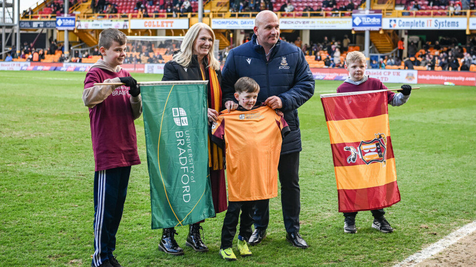 Professor Congdon and Davide Longo, Bradford City’s Chief Commercial Officer, with young flagbearers during the Takeover Day. Image credits: University of Bradford