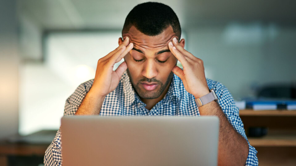Stressed out. Cropped shot of a young businessman looking stressed while working in the office.